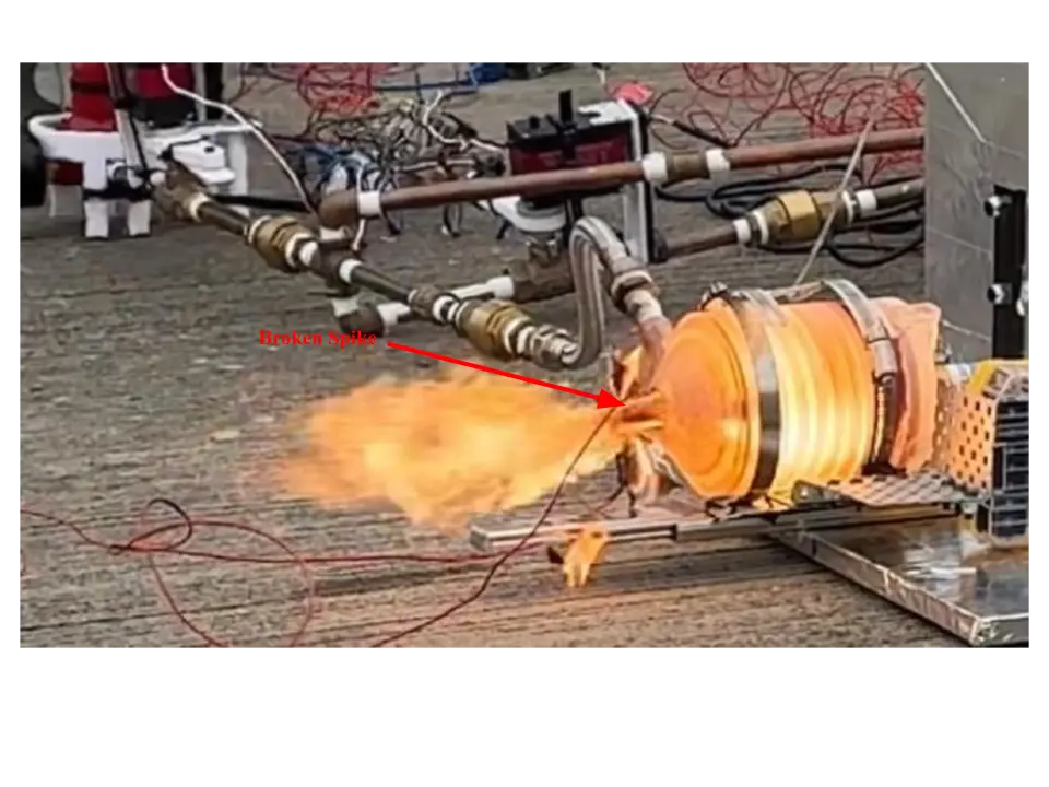 Hot-fire still with a red arrow labeled Broken Spike pointing at the nozzle end of a glowing engine while orange flame blows sideways
